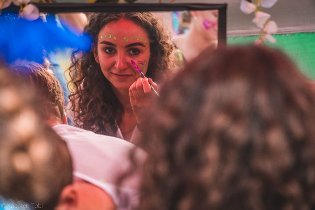 Eine junge Frau schminkt sich für das Gypsyland Festival auf Bali