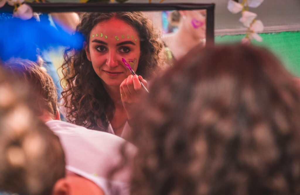Eine junge Frau schminkt sich für das Gypsyland Festival auf Bali