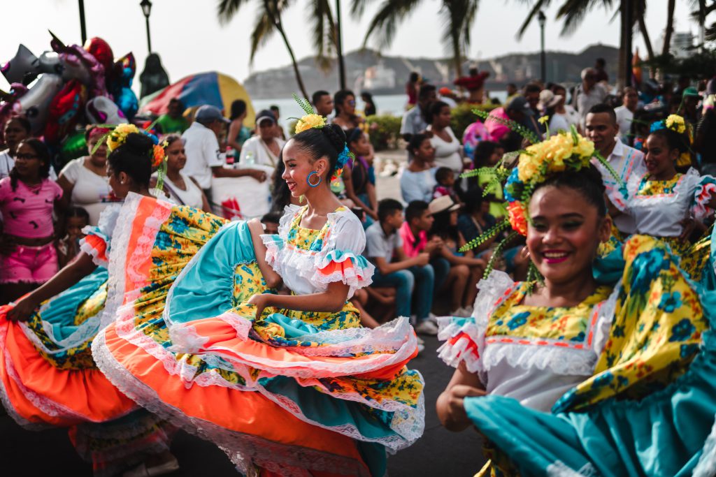 Das Fiesta del Mar in Kolumbien, zusehen auf diesem Event Foto sind zwei Tänzerinnen, die mit bunten Kleidern auf der Straße tanzen.